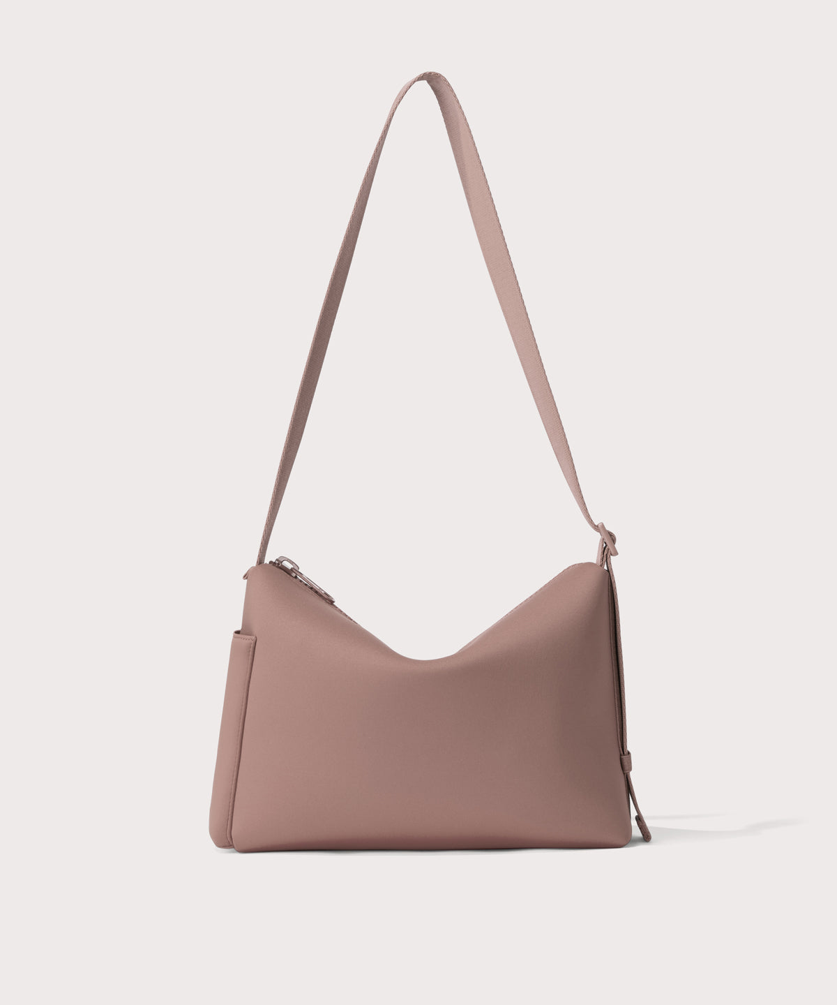 Shoulder bag in a pink seen from the back view showing phone pocket.