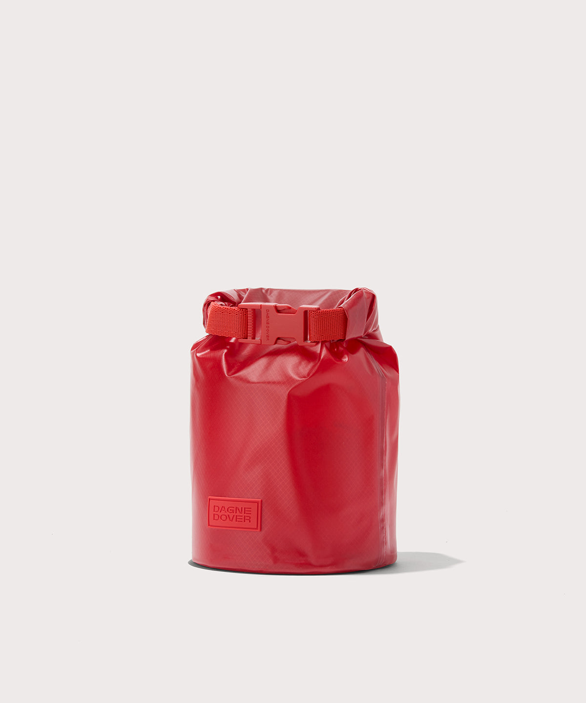 Dagne Dover Rae Roll-Top Dry Bag in a fiery, saturated red leaning toward orange seen from an angle.