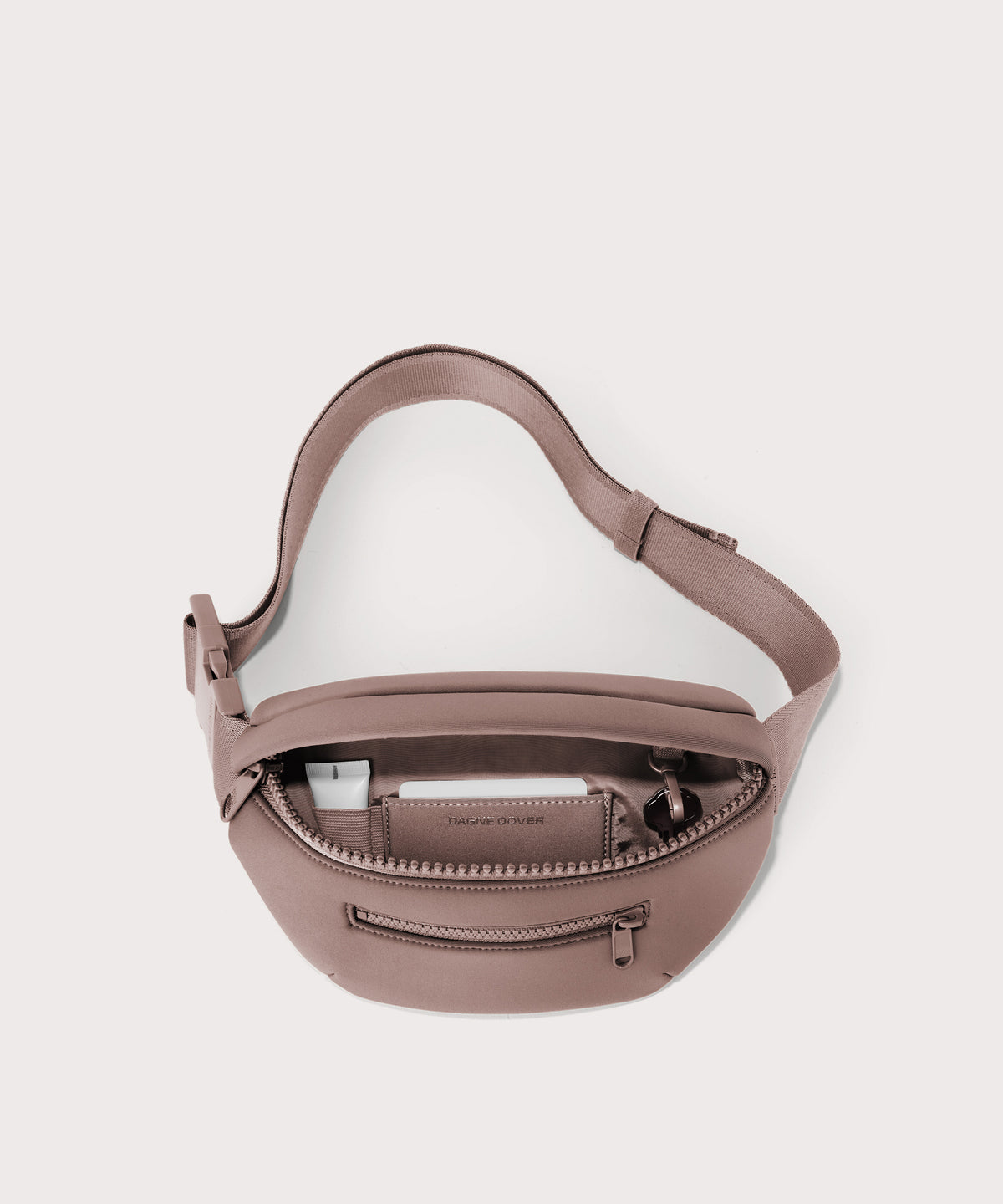 Dagne Dover Ace Fanny Pack in pink unzipped, exposing the interior pockets