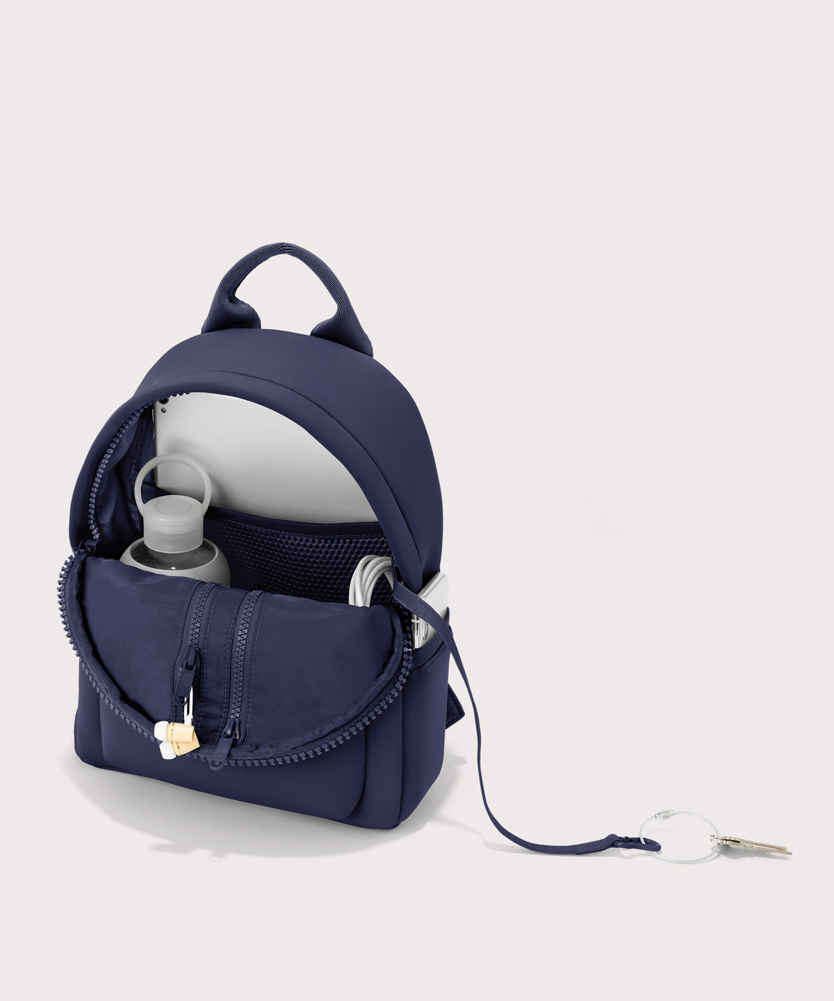Dagne Dover Dakota Small Neoprene Backpack in dark blue unzipped, revealing the interior air mesh pockets.