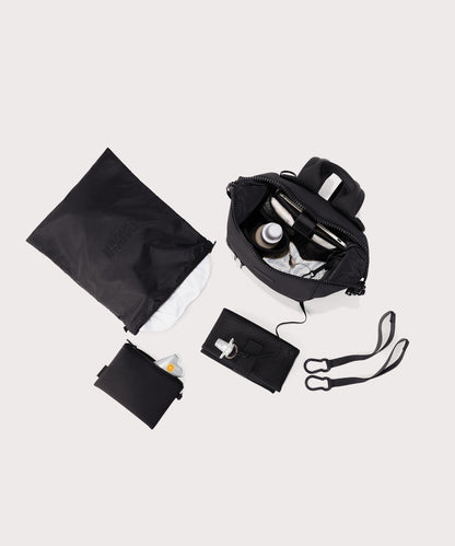 Dagne Dover small Indi Diaper Backpack in black showing it's water resistant bag, interior pockets, and changing mat.