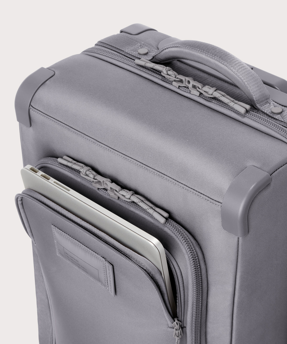 Detail shot of Seattle carry-on rolling luggage 20.5” in light grey lockable zipper heads. Lock not included.